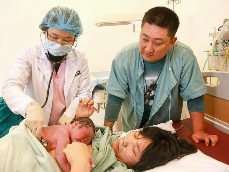 Bố mẹ ôm bé trong vòng tay, thực hiện phương pháp da kề da