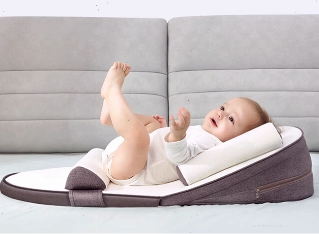 Trẻ sơ sinh nằm trên nôi, xung quanh là các vật dụng hỗ trợ giấc ngủ